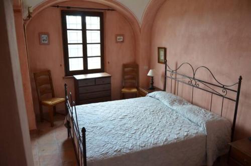 Un dormitorio con una cama grande y una ventana en Appartamento Ciro Pinsuti, en Sinalunga