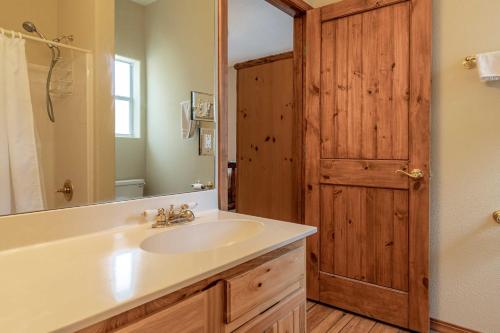 uma casa de banho com um lavatório e uma porta de madeira em Stunning Ruidoso Cabin with Private Hot Tub! em Ruidoso