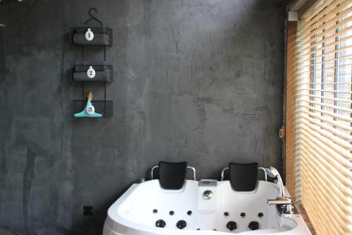 a bathroom with a white bath tub with two chairs at La maison au fil du temps in Pont-Rémy