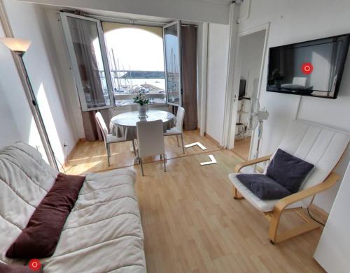 un salon avec un canapé et une table dans l'établissement Port Leucate CLAC - Appartement 2 pièces, parking privé, vue sur port, à Leucate