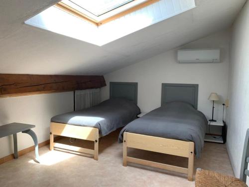 Duas camas num quarto com uma clarabóia em Gîte les Cyprès (Bastide Sainte Agnès) em Carpentras