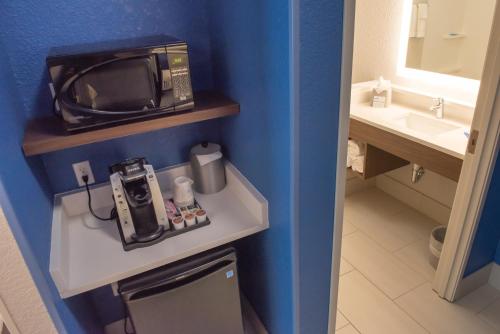 a small bathroom with a sink and a microwave at Holiday Inn Express & Suites - Dayton Southwest, an IHG Hotel in Dayton