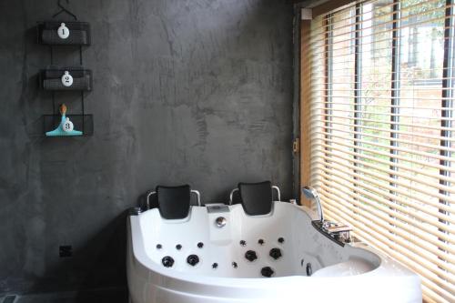 a white bath tub in a bathroom with a window at La maison au fil du temps in Pont-Rémy