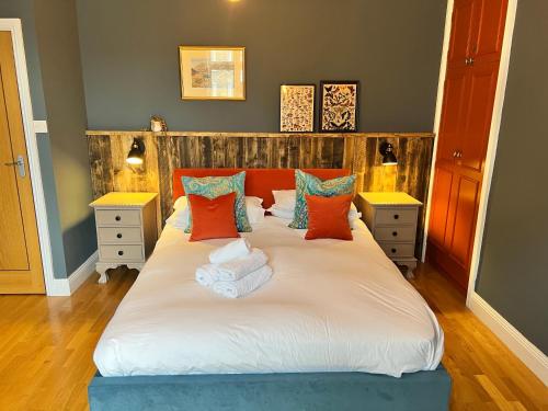 a bedroom with a large white bed with orange and blue pillows at Silver Howe, Bowness-on-Windermere in Bowness-on-Windermere