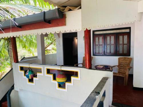 ein Haus mit Buntglasfenstern und einer Veranda in der Unterkunft Chandi Gaya Beach Guesthouse in Tangalle