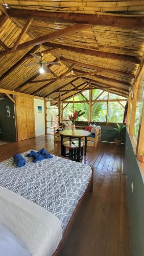 a bedroom with a bed and a table in a room at Private jungle “Loft del Rio” river access in Uvita
