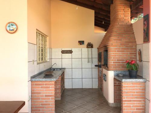 a kitchen with a sink and a brick building at Analândia - Recreio dos Netos in Analândia