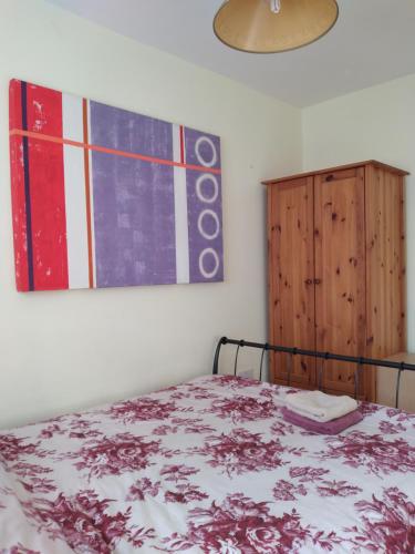 1 dormitorio con 1 cama y una pintura en la pared en 1 Double room with shared bathroom en Bracknell