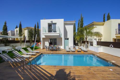 uma villa com piscina em frente a uma casa em Tsokkos Family Villa - Pool Garden Walk to Beach em Protaras