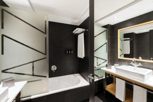 bagno con vasca e lavandino di Hotel Jazz a Barcellona