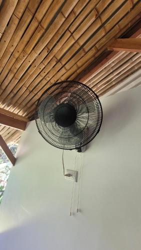 a fan hanging from the ceiling of a room at Private jungle “Loft del Rio” river access in Uvita