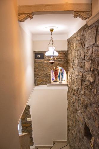 a room with a stone wall and a chandelier at Bed and Brekfast Donatella in Piran