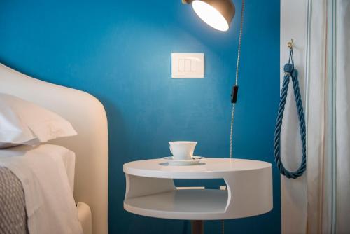 a white table with a cup on it next to a bed at SWEETSUITE Rome in Rome