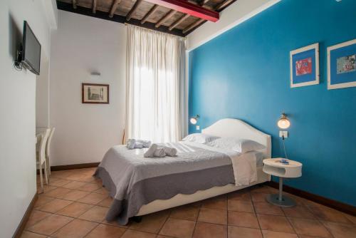 una camera da letto con una parete blu e un letto di SWEETSUITE Rome a Roma