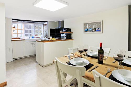 a kitchen and dining room with a wooden table and chairs at White Sails in Brixham