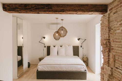 1 dormitorio con cama y pared de ladrillo en Pomalo Inn en Vis