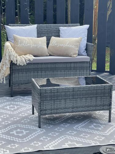 a wicker couch and a coffee table on a patio at The Old Inn Retreat in Spilsby
