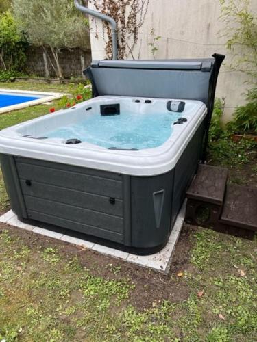 a hot tub sitting in the grass in a yard at Logis du Lièvre d'or in Montbazon
