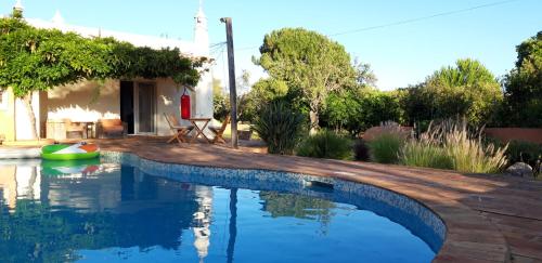a swimming pool in front of a house at Rural Peace in the Algarve - Private Room with kitchenette and bathroom in Aldeia dos Matos