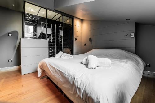 une chambre avec un grand lit avec deux serviettes dessus dans l'établissement Taur STREET 6, à Toulouse