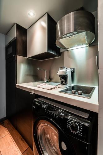 une cuisine avec lave-linge noir dans l'établissement Taur STREET 6, à Toulouse