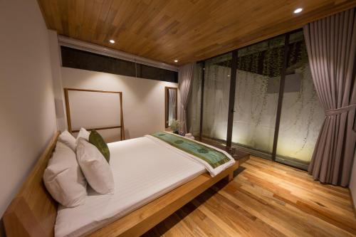a bedroom with a large bed with a window at The Purple Hue Homestay in Hue