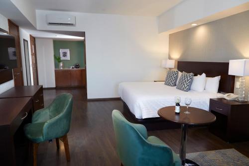 a hotel room with a bed and a table and chairs at Ejecutivo Express Guadalajara Providencia - Av México in Guadalajara