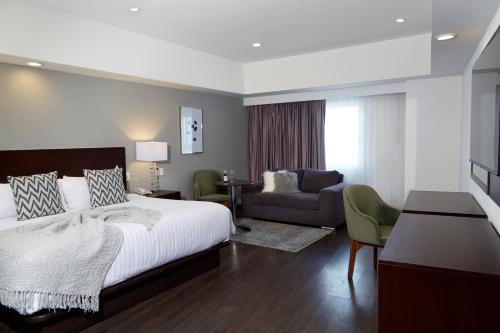 um quarto com uma cama grande e uma sala de estar em Ejecutivo Express Guadalajara Providencia - Av México em Guadalajara