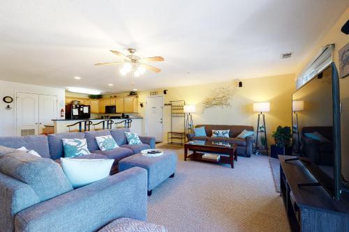 a living room with blue couches and a kitchen at Seaside - Silver Lining 202B in Virginia Beach