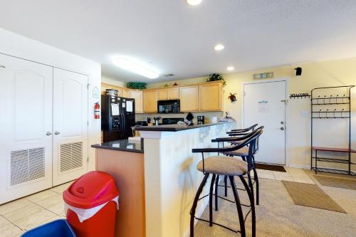a kitchen with a counter and some stools in it at Seaside - Silver Lining 202B in Virginia Beach