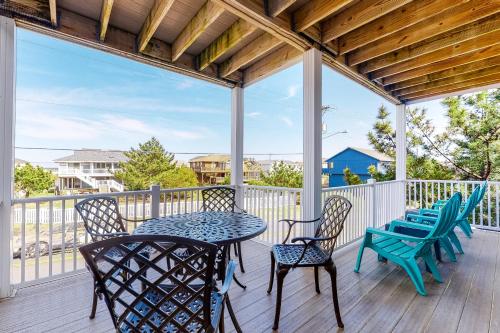 a patio with a table and chairs on a deck at Seaside - Silver Lining 202B in Virginia Beach