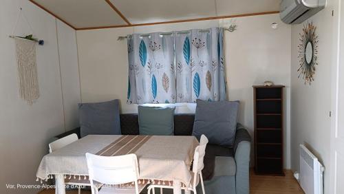 uma sala de jantar com uma mesa e cadeiras e uma janela em Mobil Home Hyères les palmiers em Hyères