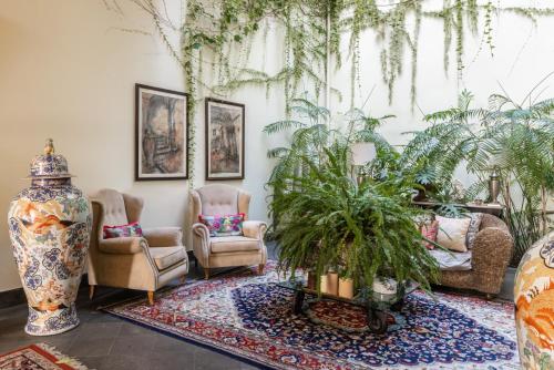 a living room with chairs and a plant on a rug at Palazzo Marziale in Sorrento