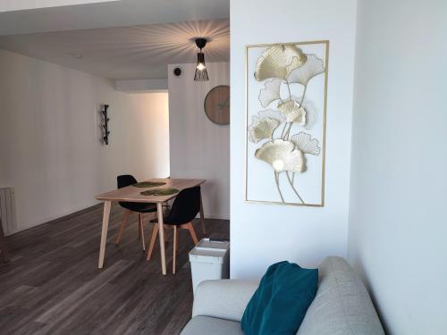 a living room with a couch and a table at Joli appartement avec jardin-terrasse privé in Brest