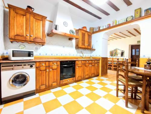 a kitchen with wooden cabinets and a checkered floor at Casa Rural Don Alonso in Villalgordo del Jucar