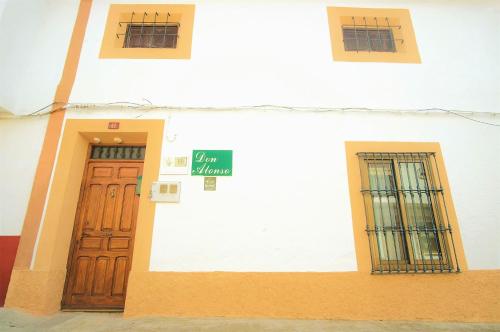 a building with two doors and a sign on it at Casa Rural Don Alonso in Villalgordo del Jucar