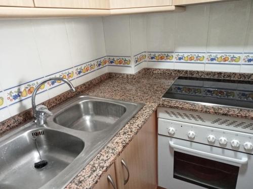 kuchnia ze zlewem i kuchenką w obiekcie PLAYA ALMARDA CORINTO, PISCINA, WIFI,2 TERRAZAS, BARBACOA,TRANQUILo w mieście Sagunto