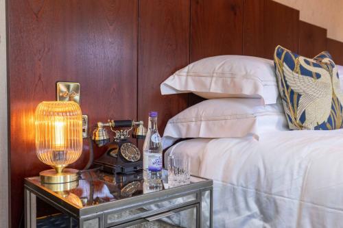 a bedroom with a bed and a table with a lamp at Ocean Mist Leith in Edinburgh