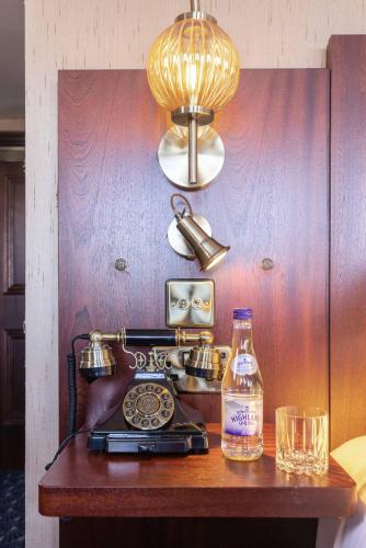 a table with a phone and a bottle of alcohol at Ocean Mist Leith in Edinburgh