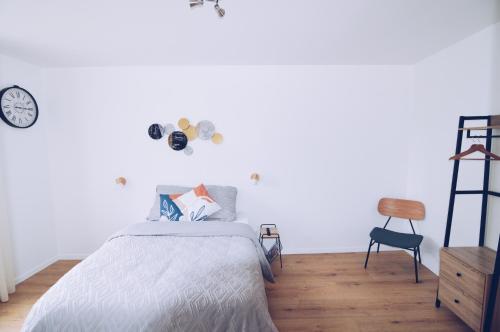 a bedroom with a bed and a ladder and a clock at Studios Lsquare-Residence in Châtellerault