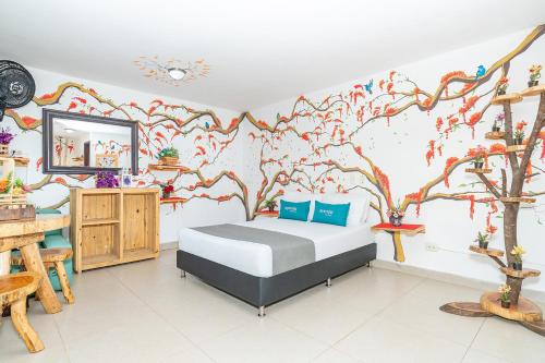 1 dormitorio con 1 cama con un mural en la pared en Ayenda Jardin de Provenza, en Medellín