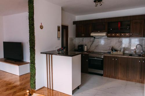 a kitchen with wooden cabinets and a counter top at Wel Apartment in Gevgelija