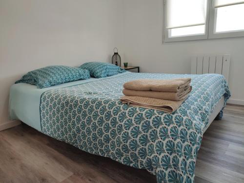 um quarto com uma cama com toalhas em Calme et charmant T1 bis em Brest