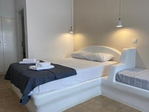 a white bedroom with two beds with towels on them at Serene Hill in Naousa