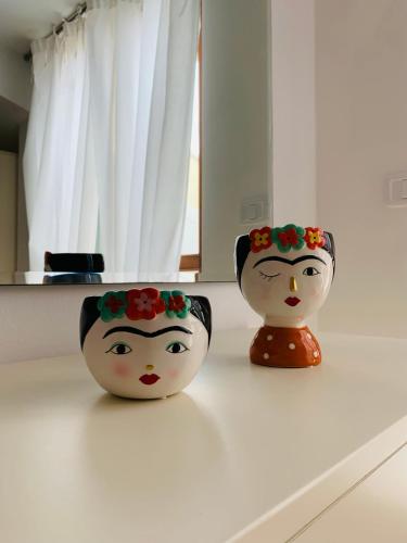 two vases with flowers on their heads sitting on a counter at Residenza l'Ulivo in Alberese