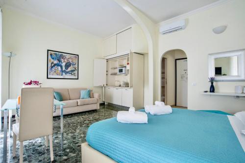a bedroom with a blue bed and a living room at SWEETSUITE Rome in Rome