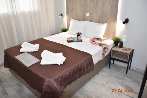 凱拉莫提的住宿－Le An Apartments Thalassa，卧室配有一张带白色枕头和桌子的大床