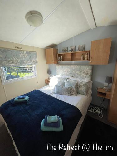 a bedroom with a large bed with a blue blanket at The Old Inn Retreat in Spilsby