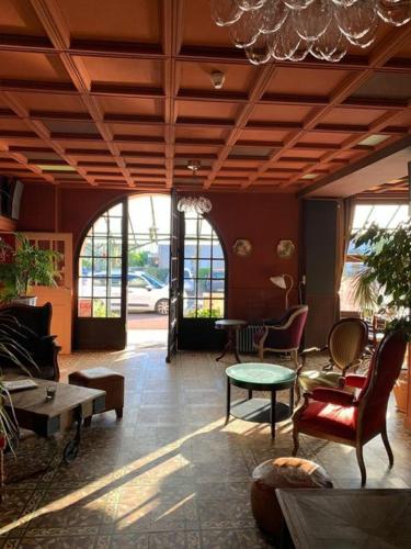 un salon avec mobilier et lustre dans l'établissement L'auberge de St Julien, à Saint-Julien-de-Jonzy