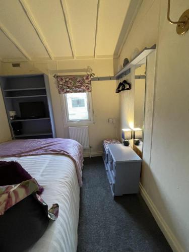 a small bedroom with two beds and a window at The Old Inn Retreat in Spilsby